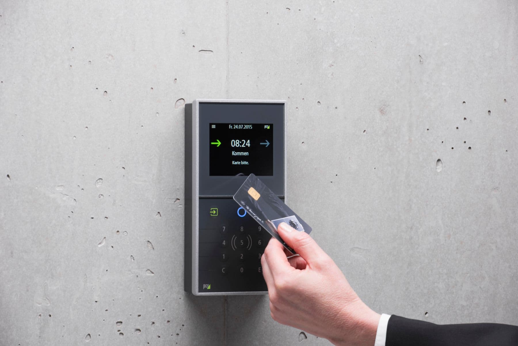 Person using a wall-mounted access control card reader