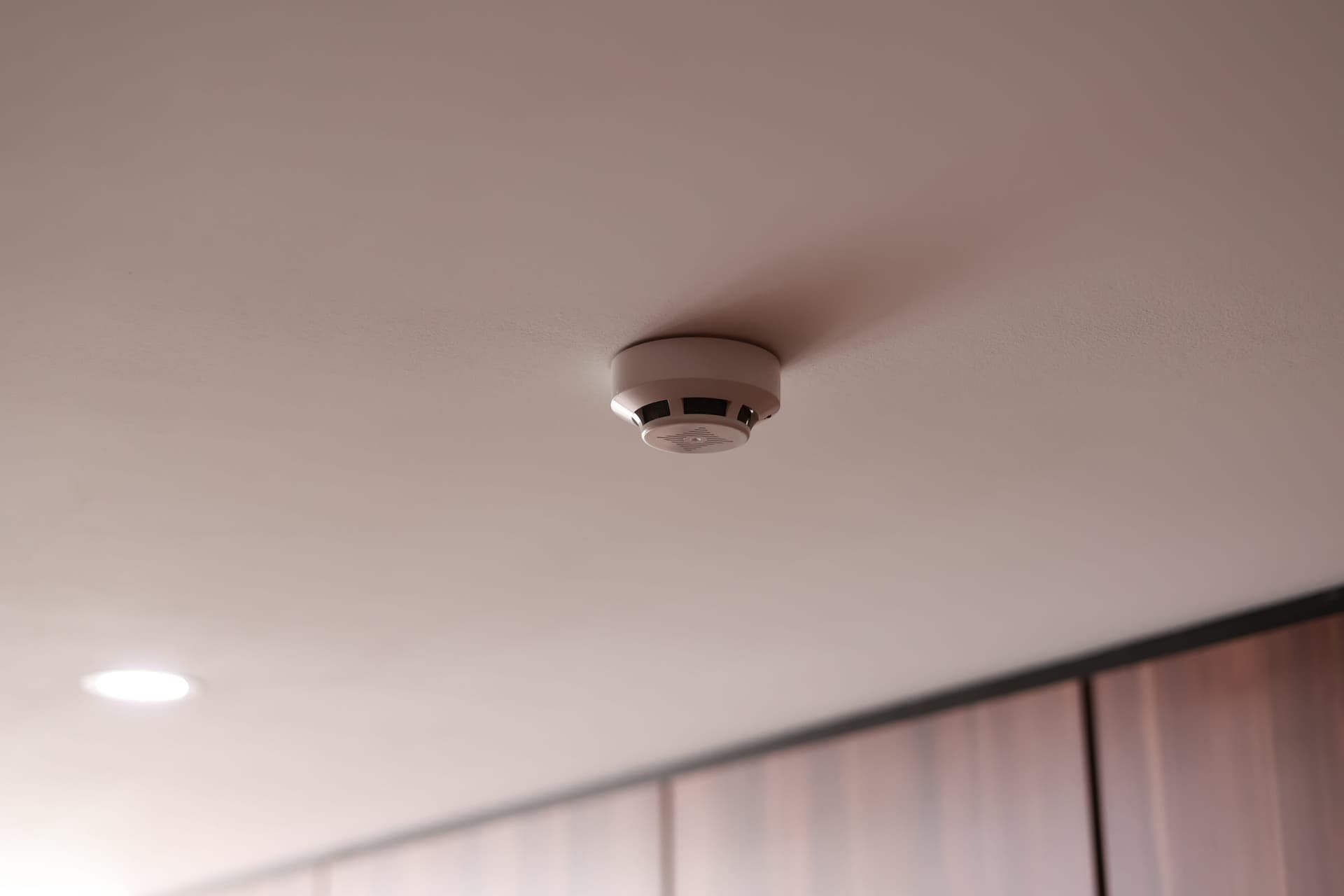 Commercial fire alarm detector mounted on a ceiling