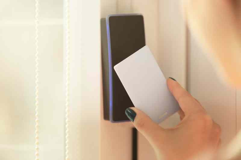 Person using a wall-mounted access control keypad
